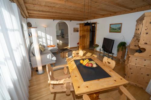 a living room with a table with a bowl of fruit on it at Chasa Nogler - Ferienwohnung in Ramosch