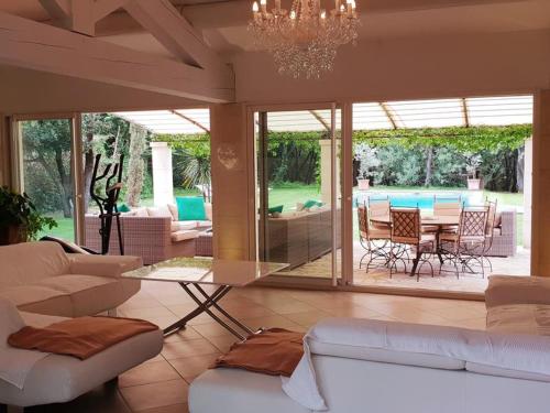 un salon avec un canapé, une table et des chaises dans l'établissement La Boisée, cadre idyllique et reposant près d'Orange, à Orange