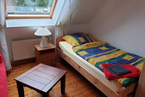 a small bedroom with a bed and a table with a lamp at Störtebecker in Wangerland