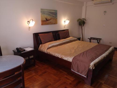 a bedroom with a bed and a table and lights at Hotel Plaza Real Suites & Apartments San Jose in San José
