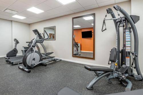 a gym with treadmills and ellipticals and a mirror at Comfort Inn Brewster in Brewster