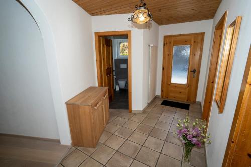 a hallway with a toilet and a vase of flowers at Chasa Nogler - Ferienwohnung in Ramosch