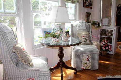 a room with two chairs and a table with a lamp at An English Garden in Dennis Port