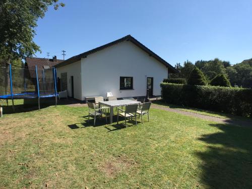 a table and chairs in the yard of a house at Villa Im Bongert - Tor zum Nationalpark Eifel in Hellenthal