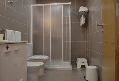 La salle de bains est pourvue de toilettes et d'une douche en verre. dans l'établissement Cerca da Vitoria 3 Milfontes, à Vila Nova de Milfontes