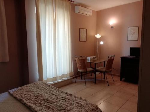 1 dormitorio con 1 cama, mesa y sillas en Residence La Palma, en Catania