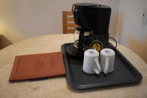 a coffee maker on a tray on a table at Hotel Palacio Azteca Tijuana, Trademark by Wyndham in Tijuana
