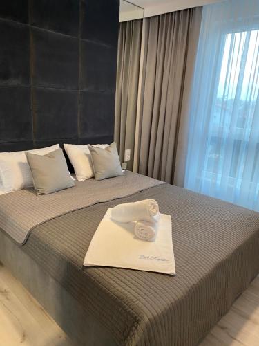 a hotel room with a bed with a towel on it at Bel Mare Comfort 305 Apartament in Międzyzdroje