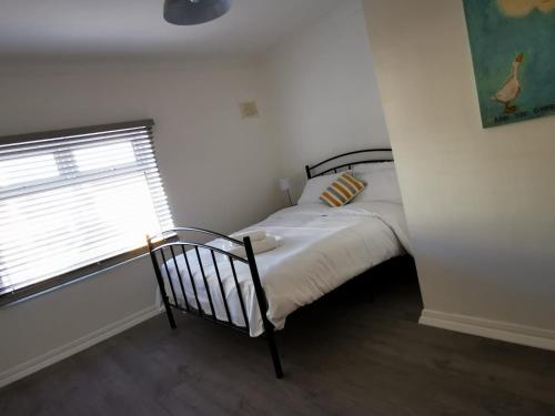 a small bedroom with a bed and a window at High Street Flats in Broadstairs