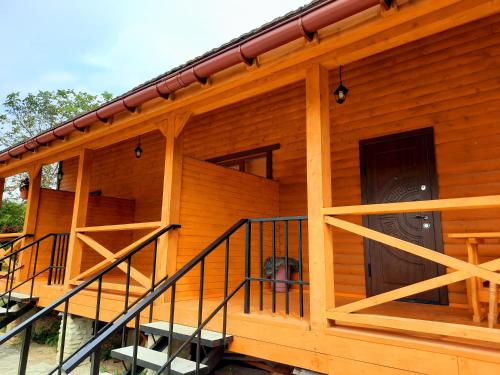 a log cabin with stairs leading to the front door at Садиба У Романа 'двохрівневий номер' in Verkhneye Sinevidnoye