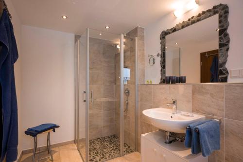 a bathroom with a sink and a shower with a mirror at Haus Enzian in Oberaudorf