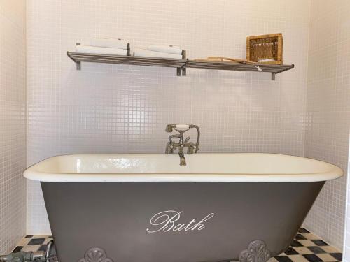 a bath tub in a bathroom with a sink at Hotel het Oude Postkantoor in Brummen