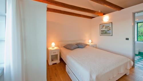 a bedroom with a white bed and two lamps at Villa Tangerine Vis in Vis