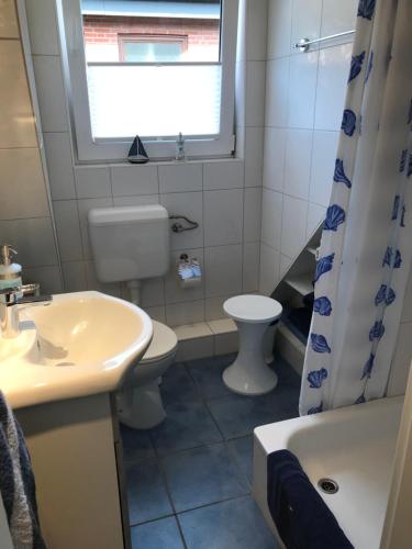a bathroom with a sink and a toilet and a window at Ferienwohnung Heikendorf in Heikendorf