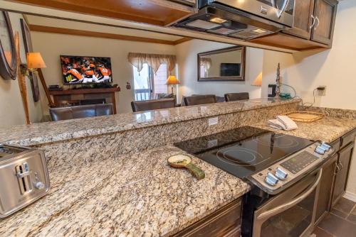 a kitchen with a granite counter top with a sink at Mountainside 343B in Frisco