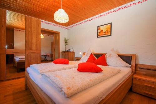 a bedroom with a large bed with red pillows at Beim Appertinger in Truchtlaching
