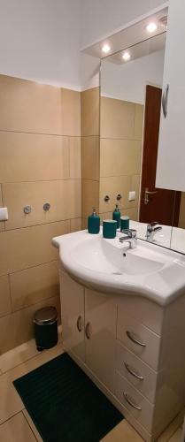 a bathroom with a white sink and a mirror at Ferienwohnung am Waldsee mit Schwimmbad in Gernsbach