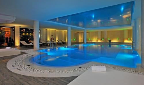 a large swimming pool in a building with blue lighting at Iberostar Waves Royal Andalus in Chiclana de la Frontera