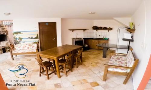 a kitchen with a wooden table and chairs at Residencial Ponta Negra Flat in Natal