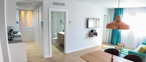 a living room with a dining table and a living room with a couch at Sea to Sky Suites - Mijas Pueblo in Mijas