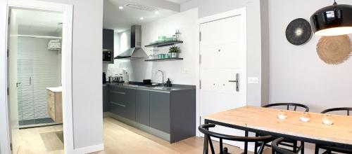 a kitchen and dining room with a wooden table at Sea to Sky Suites - Mijas Pueblo in Mijas