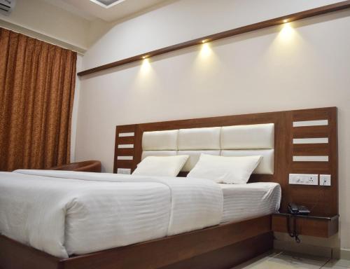 a bedroom with a large bed with white sheets at Bhramari Nest in Subrahmanya