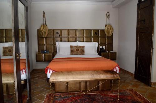 a bedroom with a bed and a bench in a room at Casa 1810 Hotel Boutique in San Miguel de Allende
