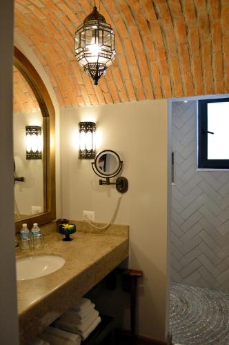 a bathroom with a sink and a chandelier at Casa 1810 Hotel Boutique in San Miguel de Allende