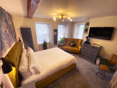 1 dormitorio con cama, sofá y TV en The Hive at Poppi-Red en Hawkshead