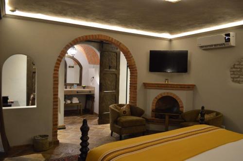 a bedroom with a fireplace and a tv on the wall at Casa 1810 Hotel Boutique in San Miguel de Allende