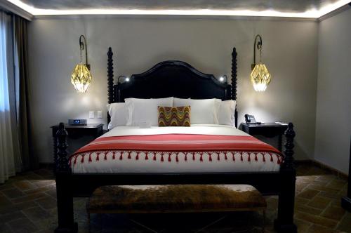 a bedroom with a large bed and two lights at Casa 1810 Hotel Boutique in San Miguel de Allende