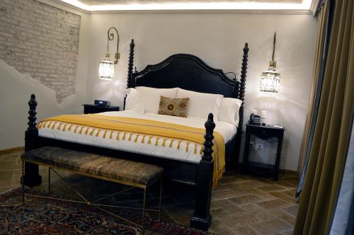 a bedroom with a king sized bed and a bench at Casa 1810 Hotel Boutique in San Miguel de Allende