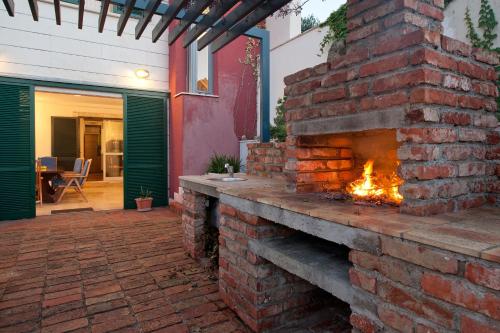 a brick fireplace in a yard with a patio at Villa Tangerine Vis in Vis
