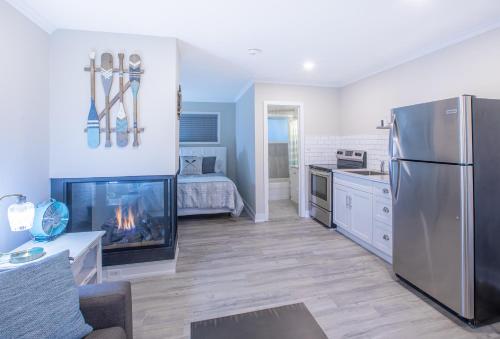 a kitchen and living room with a fireplace and a refrigerator at Boutique Suite #2 in Blue Mountains