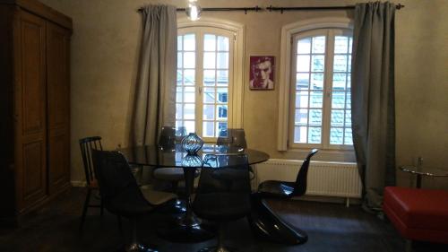 a dining room with a table and chairs and windows at Manoir -1654- historisch schlafen in Monschaus Altstadt in Monschau