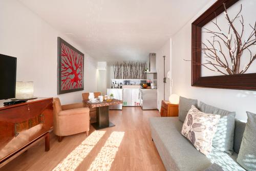 ein Wohnzimmer mit einem Sofa und einem Tisch sowie eine Küche in der Unterkunft Renovated Charming Apartment, By TimeCooler in Lissabon