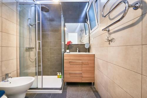 een badkamer met een douche, een wastafel en een toilet bij Renovated Charming Apartment, By TimeCooler in Lissabon
