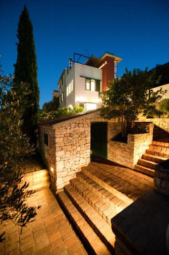 a house with a stone wall and stairs in front at Villa Tangerine Vis in Vis