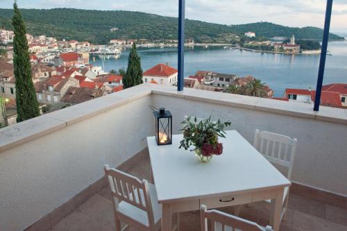 a white table with flowers and a candle on a balcony at Villa Tangerine Vis in Vis