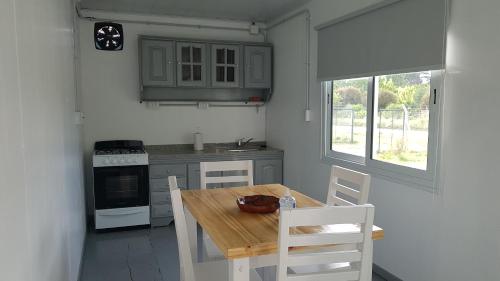 eine kleine Küche mit einem Holztisch und Stühlen in der Unterkunft TERRABOX Apart de contenedores in Olivera