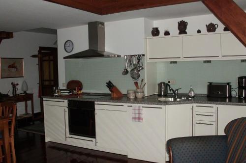 a kitchen with white cabinets and a stove top oven at Ferienwohnung Haumannshof in Xanten