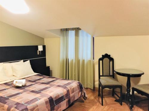 sypialnia z łóżkiem, stołem i krzesłami w obiekcie Hostal Carlos Tenaud w mieście Lima