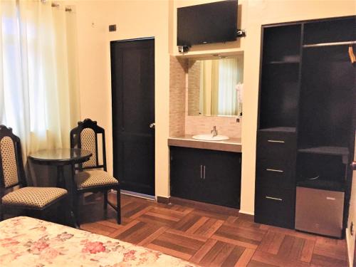 Habitación con baño con lavabo y mesa. en Hostal Carlos Tenaud, en Lima