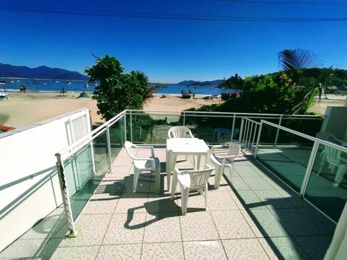 a balcony with a table and chairs and a beach at Solar Dona Maria in Pinheira