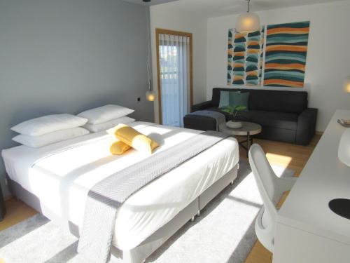 a bedroom with a large white bed and a couch at Panoramic in Travel, Parque das Nações in Lisbon