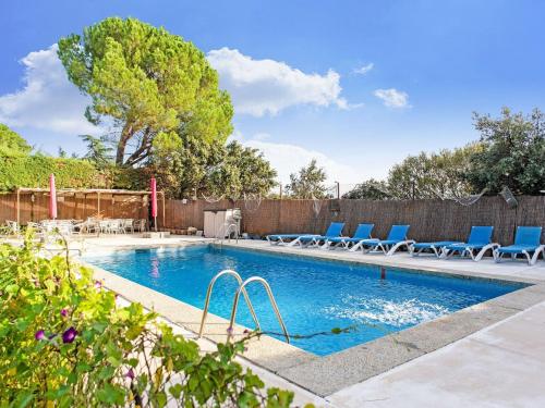 una piscina con sillas azules y una valla en Rural apartment with shared garden pool and Spa, en Galapagar