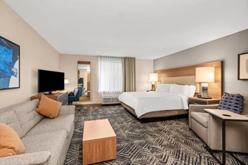 a hotel room with a bed and a couch at Candlewood Suites Sumner Puyallup Area by IHG in Sumner