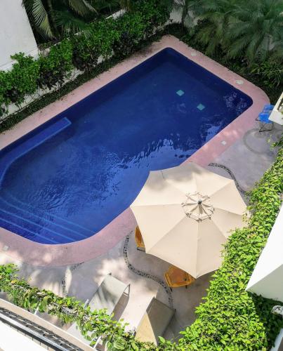 an overhead view of a swimming pool with an umbrella at Hotelito Los Sueños in Sayulita
