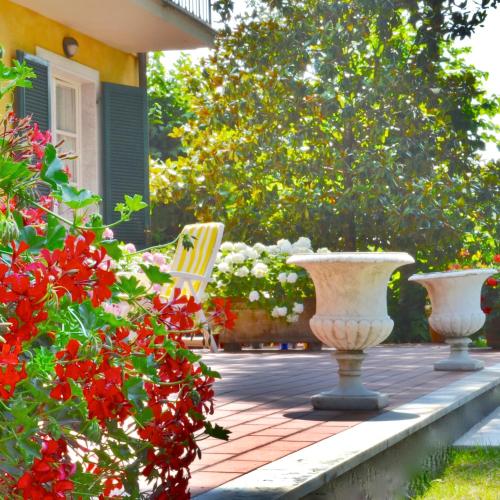 three vases sitting on a patio with flowers at Hotel Villa Fiorisella in Marina di Massa