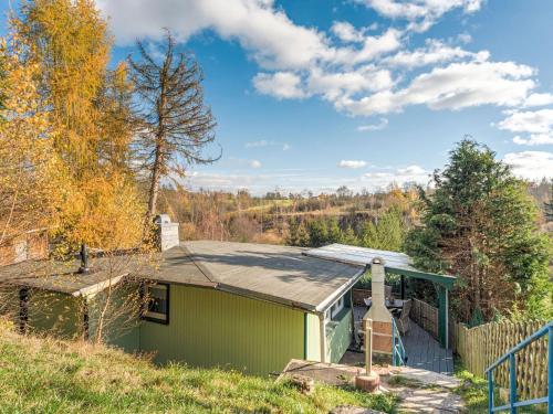 una casa verde con techo verde y valla en Holiday home with terrace next to the forest, en Allrode